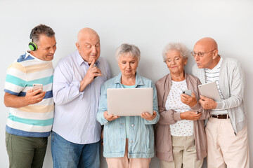 Wall Mural - Senior people with different devices near light wall in room