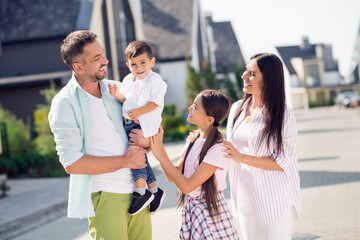 Canvas Print - Photo of optimistic funny family look small boy walk near home wear casual cloth outside