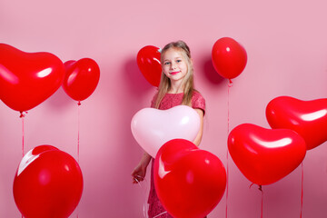 Wall Mural - Valentines day. Little cute girl with red heart balloons on pink background