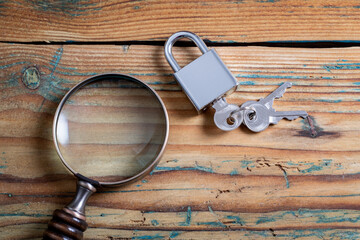 Wall Mural - information, internet and data security concept. padlock and magnifying glass on a wooden background