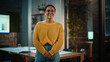 © Gorodenkoff - Portrait of a Young Latina with Short Dark Hair and Glasses Posing for Camera in Creative Office Environment. Beautiful Diverse Multiethnic Hispanic Female Wearing Yellow Jumper is Happy and Smiling.