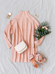 Wall Mural - Pink knitted sweater dress, small bag with chain strap, heeled sandals, bouquet of roses and eucalyptus on gray background. Women's stylish spring outfit. Trendy casual clothes. Flat lay, top view.