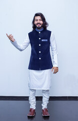 Pakistani Man Pointing with both hands fingers at right side with corse legs on white background at studio.