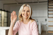 © Face Stock - Webcam view of a charming blonde mid age women having video conference, a cheerful female waving into camera and smiles, virtual meeting concept, video call to employee, coworker, friend