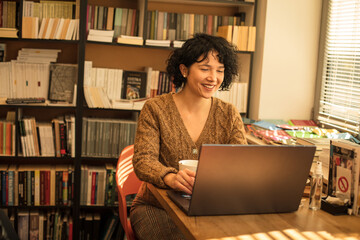 Wall Mural - woman in library using laptop. 