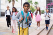 © JackF - Portrait of african american boy standing near school, children on background