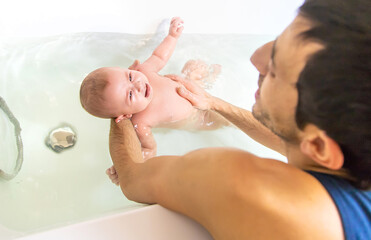 Poster - Little baby crying is afraid to swim in the bathroom. Selective focus.