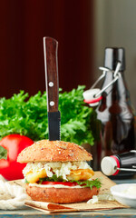 Wall Mural - Fish burger. Delicious burgers with fried white fish (cod, pollock, perch, hake), tomatoes, lettuce,  cabbage with tartare sauce on a whole-grain bun. Fast food for beer. Selective Focus