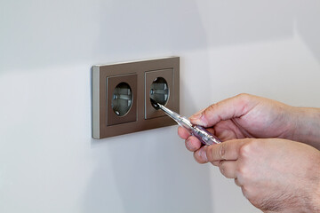 handyman removes frame from electrical outlet to fix problem