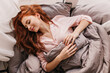 © Look! - Appealing long-haired woman sleeping in morning. Inspired ginger girl lying in bed.