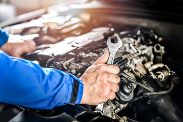 Poster - Mechanic with wrench in hands near car engine.