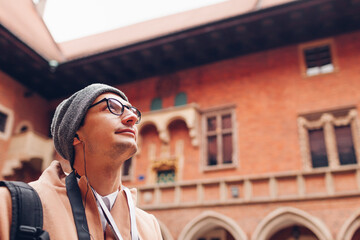 man tourist enjoys excursion in medieval jagiellonian university, collegium maius, krakow, poland us