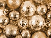 Close Up Top View Of Pile Scattered Golden Christmas Balls,various Sizes.Festive Shiny Gold,disco Mirror Decorations On Shimmering Backdrop.Concept Of Holiday,celebration,card Design ,discounts,banner