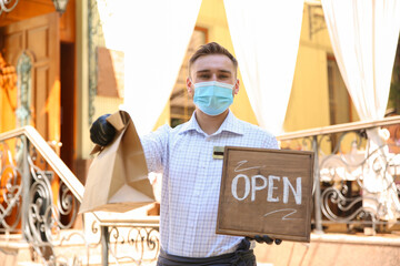 Sticker - Waiter with packed takeout order and OPEN sign near restaurant. Food service during coronavirus quarantine