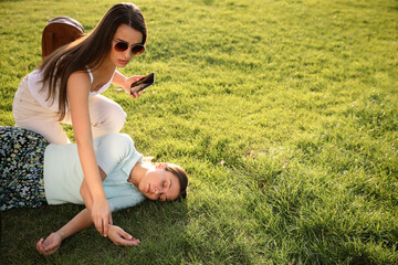 Canvas Print - Woman checking pulse of unconscious person with heart attack in park