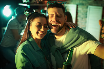 Wall Mural - Couple with beer celebrating St Patrick's day in pub