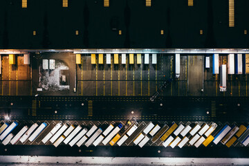 Wall Mural - Aerial view of the trucks unloading at the logistic center. Night view with a bit of snow.