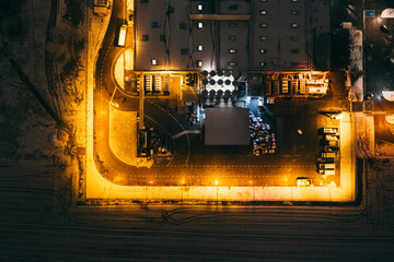 Aerial view of the trucks unloading at the logistic center. Night view with a bit of snow.