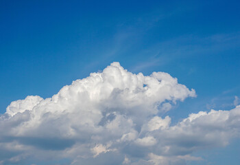 big white fluffy cloud in deep blue sky in summer morning