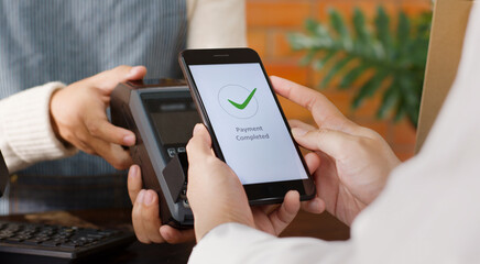 Customer using phone for payment at cafe restaurant, cashless technology and money transfer concept