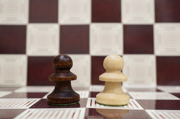 Wall Mural - Close-up shot of a black and white wooden Pawns on the chess board