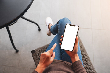 top view mockup image of a woman holding mobile phone with blank white desktop screen
