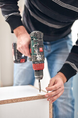 Wall Mural - Handyman worker assembling furniture and fixing it.