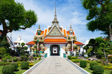 Wat Arun Raj Tharam - Two giant statues holding their batons in front of the temple entrance, Bangkok, Thailand.