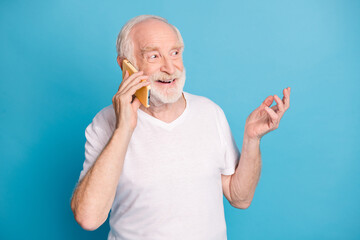 Wall Mural - Photo of cheerful aged person speaking phone have good mood isolated on pastel blue color background