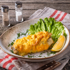 Wall Mural - Baked fish under cheese on a plate