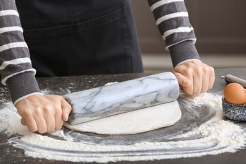 Woman making dough in kitchen