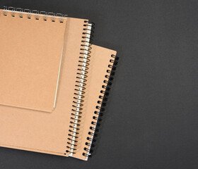 Wall Mural - closed notepad with brown sheets on black background