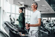 © Тарас Нагирняк - Two men on a treadmill in the gym, in focus a gray-haired, smiling senior man. Sports, training, health. Sports Hall