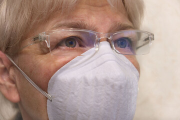 Close up senior woman  wearing glasses and face mask during corona virus and flu outbreak. Disease and illness protection.