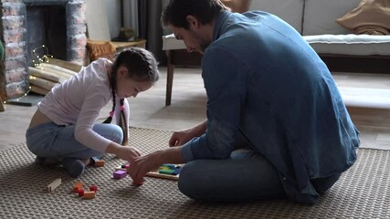 Wall Mural - Happy parent dad helping daughter playing toys together on floor, having fun