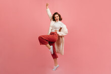Full Length View Of Pleased Young Lady In Coat. Studio Shot Of Positive Girl Fooling Around On Pink Background.