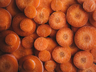 Wall Mural - orange food background. close-up of circular sliced carrots. Bunch of orange organic carrots.. colorful food