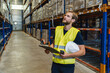 © SYCprod - young warehouse manager checking goods using a clipboard in a warehouse