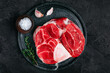 © Ekaterina Kondratova - Raw Osso Buco Meat with seasonings on dark stone background.