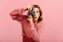 Emotional Young Lady Taking Pictures. Studio Shot Of Brunette Woman With Camera Isolated On Pink Background.