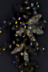 Wall Mural - shiny glimmer abstract on black background, made with a jewel out of focus.