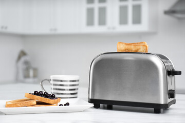 Canvas Print - Modern toaster and tasty breakfast on white table in kitchen