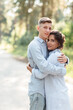 © Andriy Medvediuk - Cheerful young woman and man are hugging outdoors in summer park. couple in love having date and romantic vacation on sunny day. Love and relationships between young people
