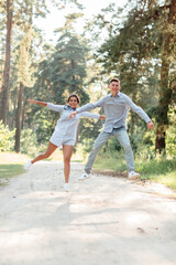 young couple in love having fun and enjoying the beautiful summer nature. woman and man, wearing in denim outfit are having date outdoors in the park. Romantic relationship. valentines day