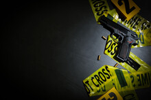 Flat Lay Composition With Gun And Crime Scene Tape On Black Slate Background. Space For Text