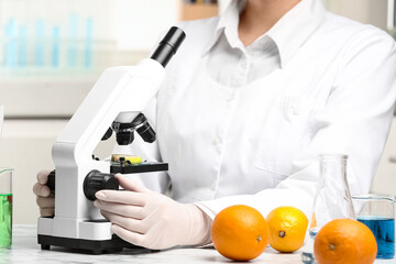 Wall Mural - scientist inspecting slice of apple with microscope in laboratory, closeup. poison detection