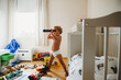 © Cavan Images - Child in diapers playing in his messy room pretending he's a pirate