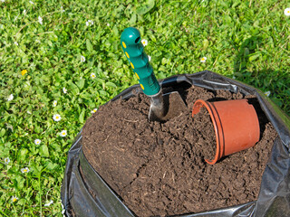 Blumenerde im Sack mit Schaufel und Blumentopf