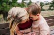 © Cavan Images - Mother holding and comforting young son outside