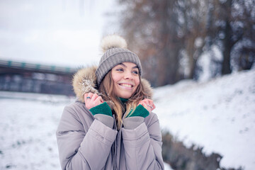 Girl in a warm hat in winter, happy woman laughs, positive emotions